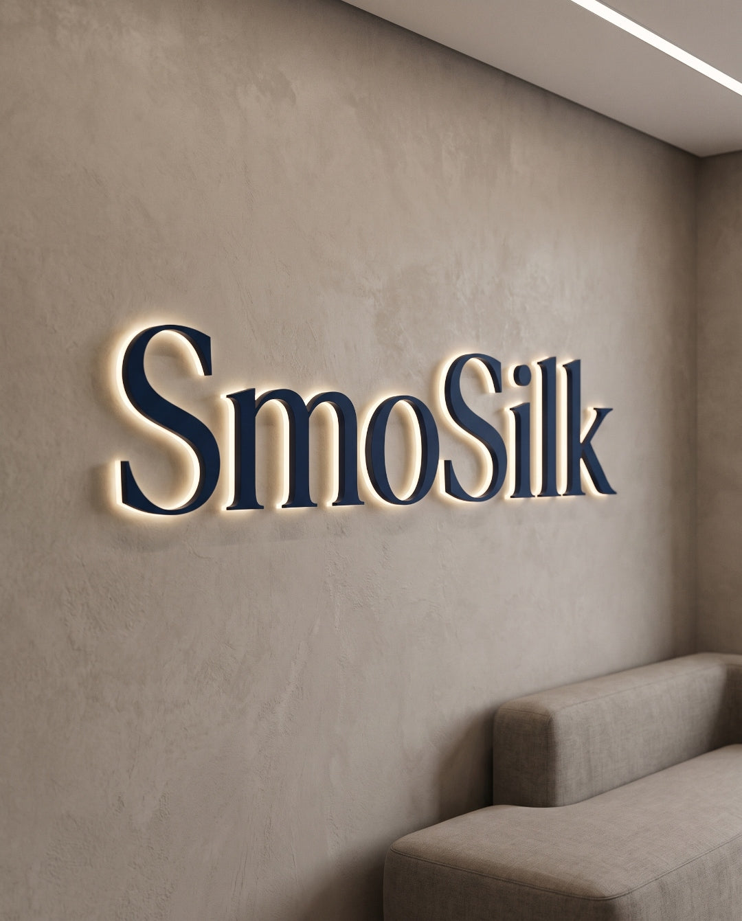 The SmoSilk wordmark in navy lettering, backlit on a plaster wall